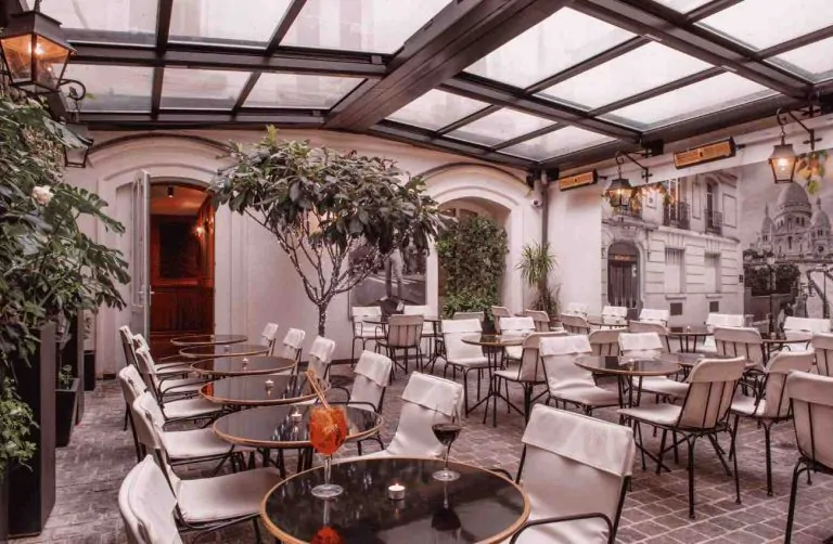 Covered restaurant terrace with tables and plants