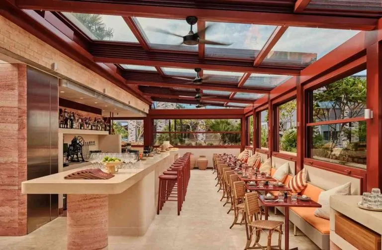 Restaurant terrace with integrated shading beneath a moving glass roof system